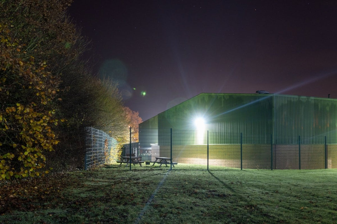 Warehouse building lit up with a bright wall pack security light